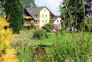 Blick durch den blühenden Garten auf das Haus